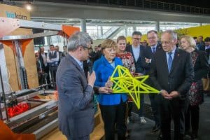 German Chancellor Angela Merkel standing near the BigRep ONE with a 3D printed stool