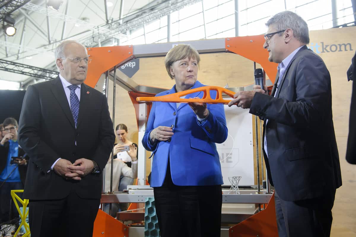 Angela Merkel with a 3D printed part and René Gurka