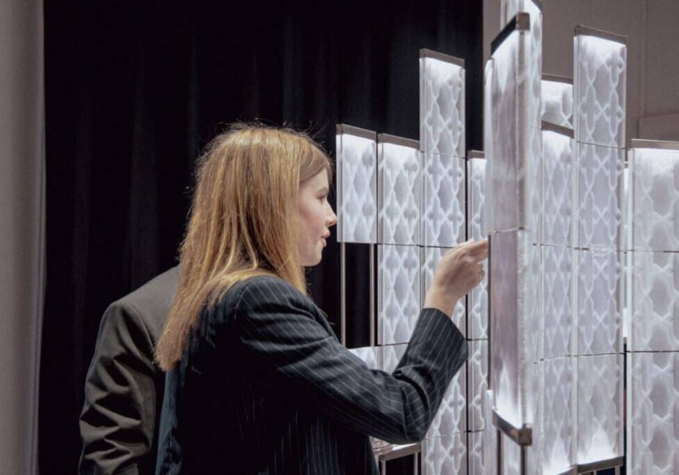 A woman looking closely at a 3d printed architecture installation -Infill Heritage